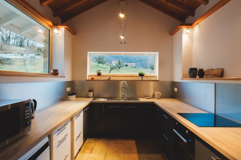 Cuisine ouverte et salon lumineux du Gîte Au Verger, avec poutres apparentes et espace convivial idéal pour des moments en famille.
